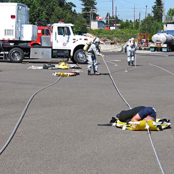 A group of people laying on the ground using the Shuttle Sked® Rope Kit in Yellow Bag.