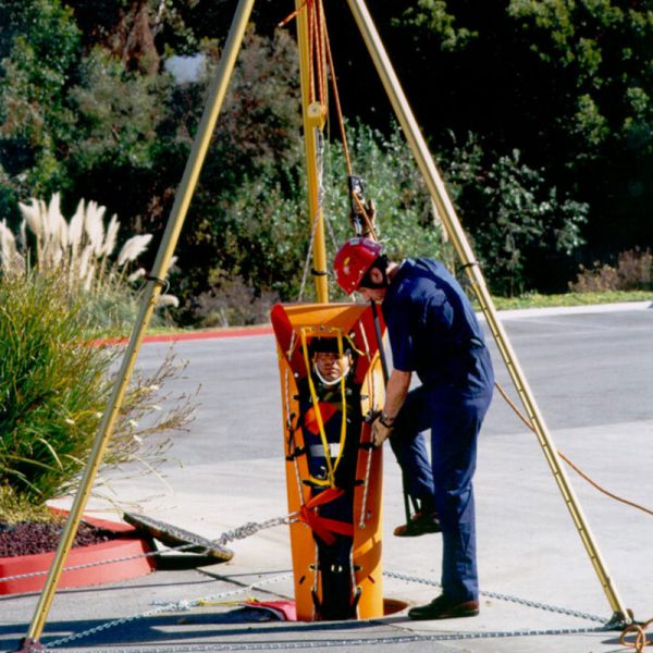 A man in a blue shirt is putting on a SKED-EVAC® TRIPOD, EN 795 Certified.