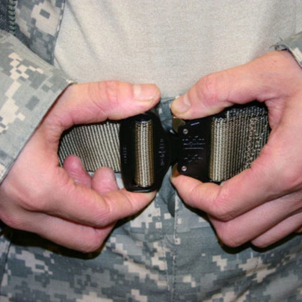 A person in a military uniform holding a SKEDCO Combat Utility Belt (Available in S, M, L & XL).