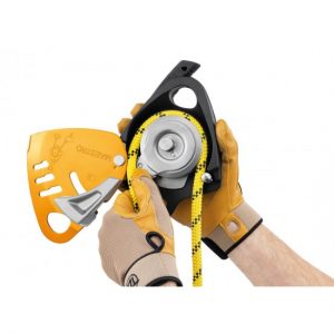A person is holding a D024AA00 PETZL MAESTRO® S DESCENDER with a yellow handle.