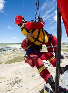 A man is hanging from a red parachute.