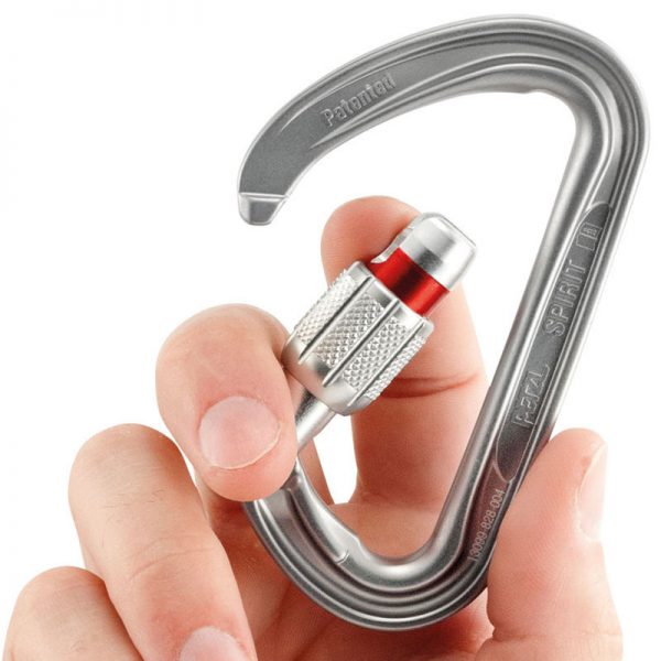 A person holding a carabiner in their hand.