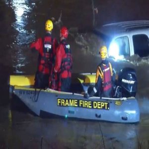 Three men in frame fire department boat