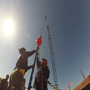 Two men wearing helmet holding a rope